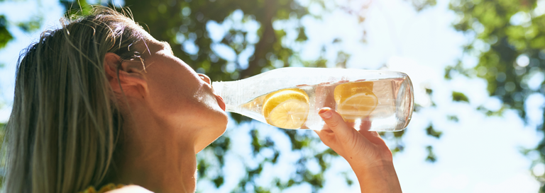 Eine Frau trinkt Limonade aus einer Flasche