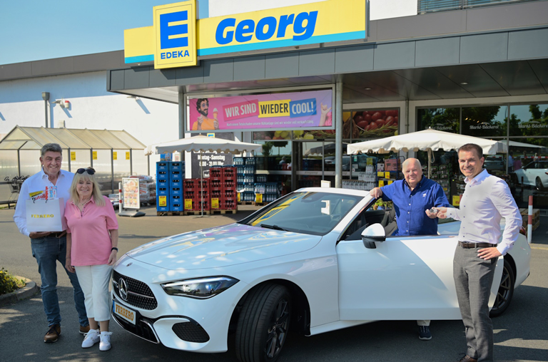Der glückliche Gewinner Jürgen H. und seine Frau Irmgard H. aus Frankfurt nehmen die Autoschlüssel von EDEKA-Kaufmann Uwe Georg und Heiko Mayer von Ferrero entgegen. Foto: Detlef Möbius